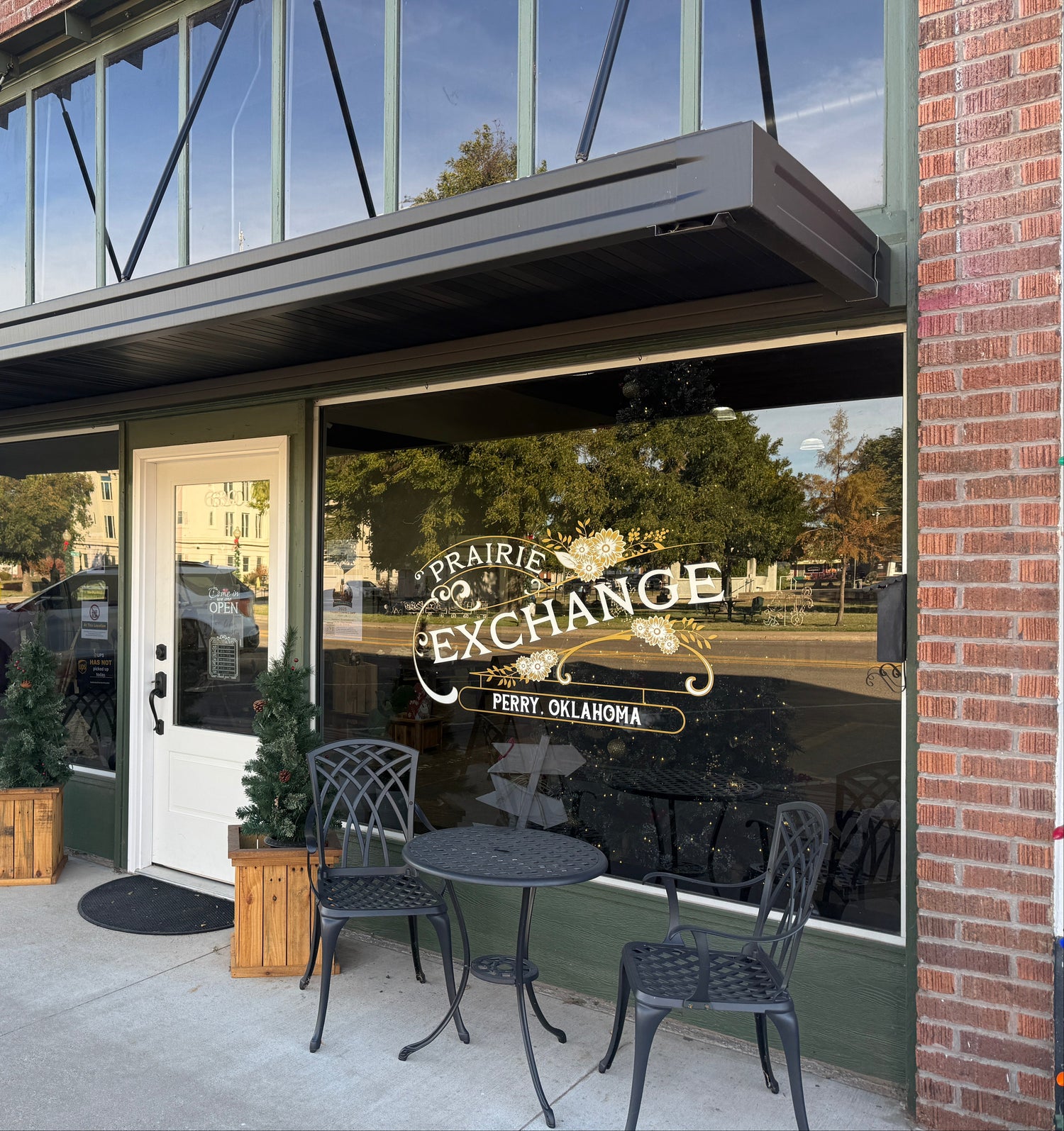 Storefront with outdoor seating area and a large window with a Prairie Exchange decal.